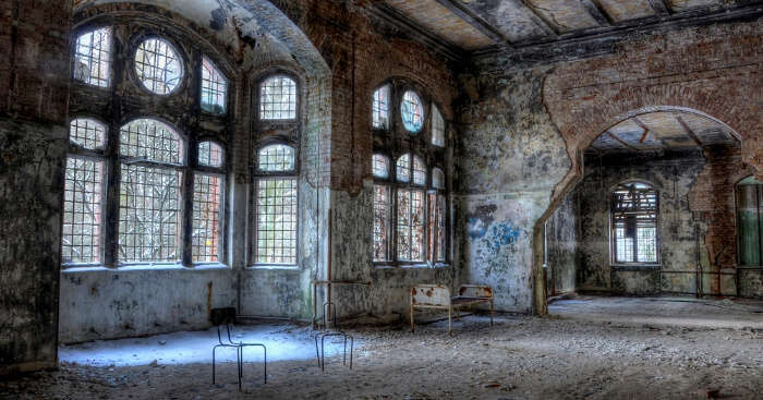 a creepy hospital with bed and chairs