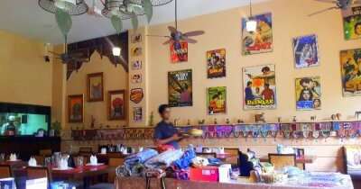 Bollywood theme restaurant with pictures of hindi movies hung on wall