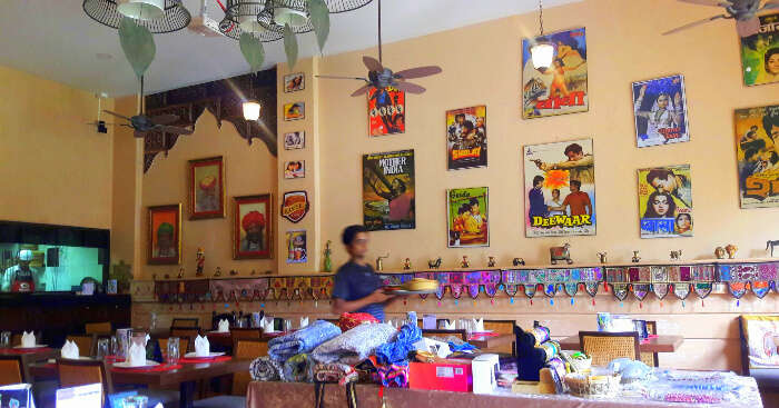 Bollywood theme restaurant with pictures of hindi movies hung on wall