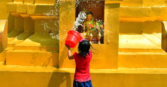 A girl washing the Buddha idol in Namphake Village in Dibrugarh, Assam