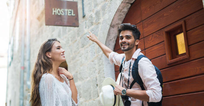 A couple pointing out to a hotel board