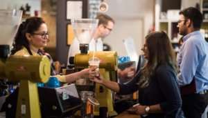 woman serving coffee to the customer