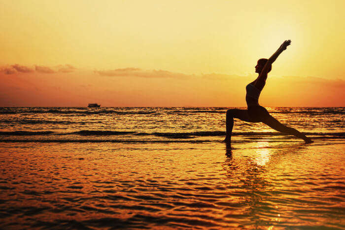 A woman doing yoga on the beach
