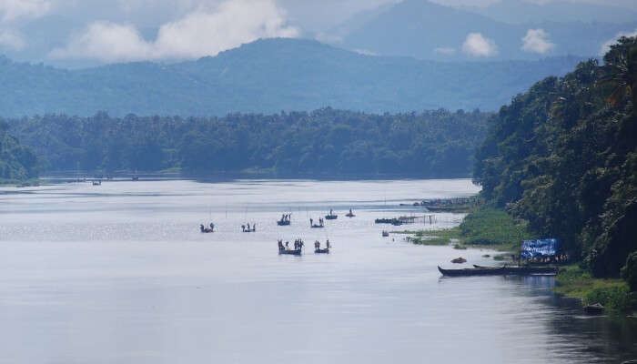 view of boats on a river and mountains on backdrop