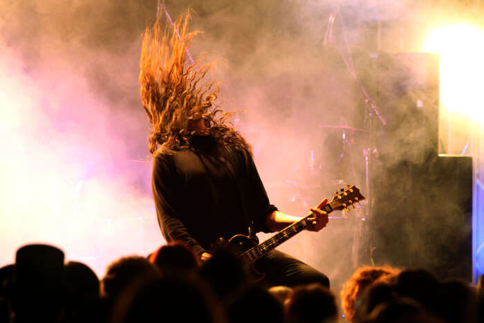 An artist banging head while playing the rock guitar