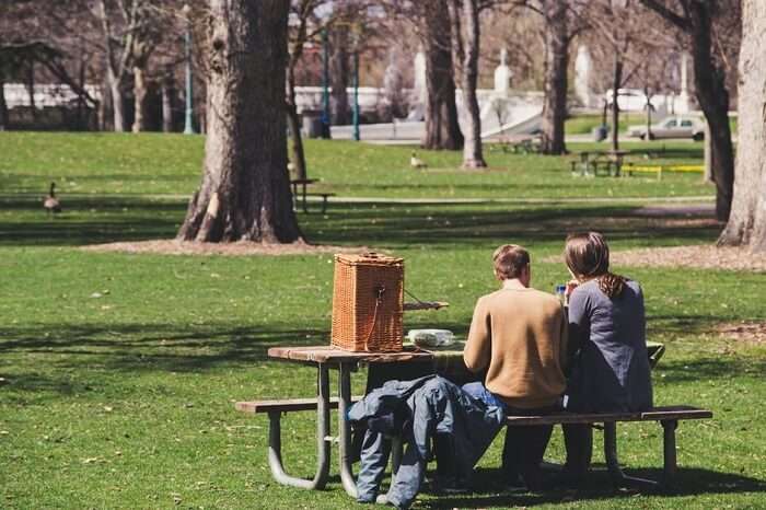 couple sitting in a park bench for picnic