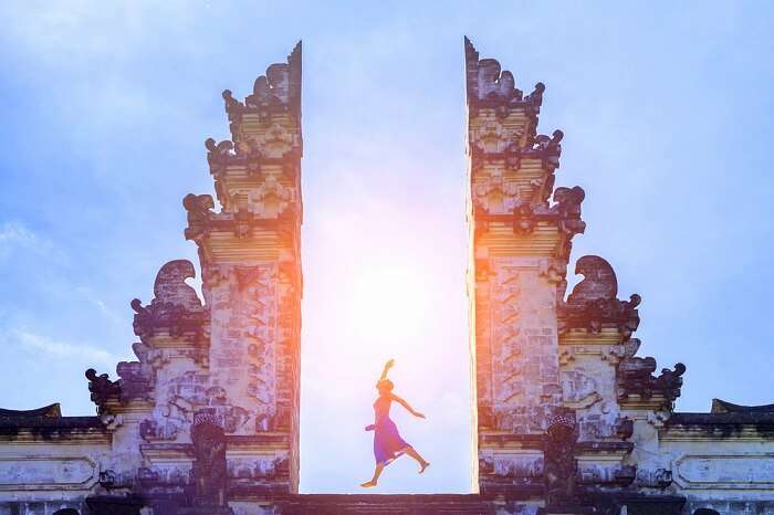 Girl posing at the gate of temple of Bali