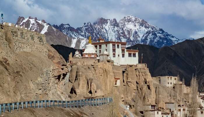 view of the mountains, monastery, and snowcapped mountains at the background