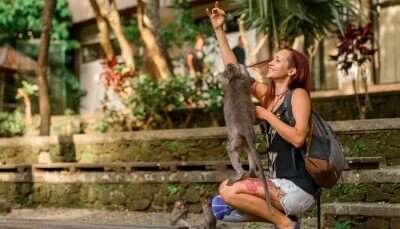 girl playing with a monkey in a zoo