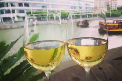 glasses of wine with singapore river in background