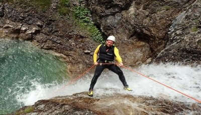 man climbing waterfall