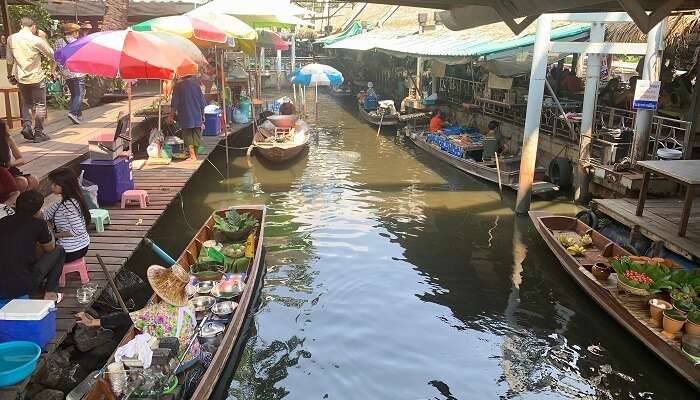 Buying some local goods at Taling Chan floating market in Bangkok is one of the best things to do in Thailand with kids