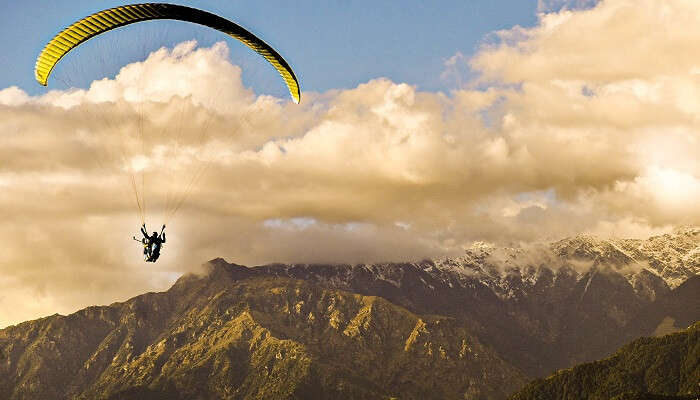 Tourist enjoying paragliding at one of the best places to visit in India