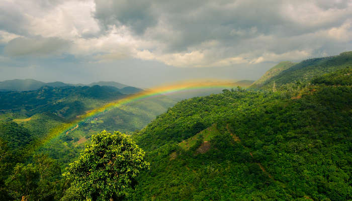 Beautiful rainbow and rainy clouds over the mountains