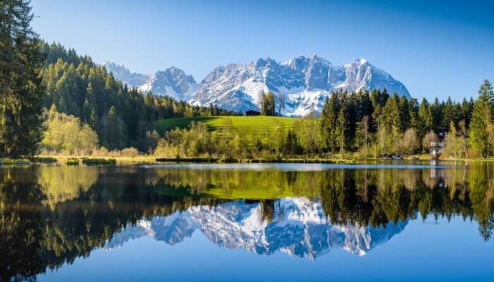 Paysage alpin idyllique Montagnes enneigées se reflétant dans un petit lac,