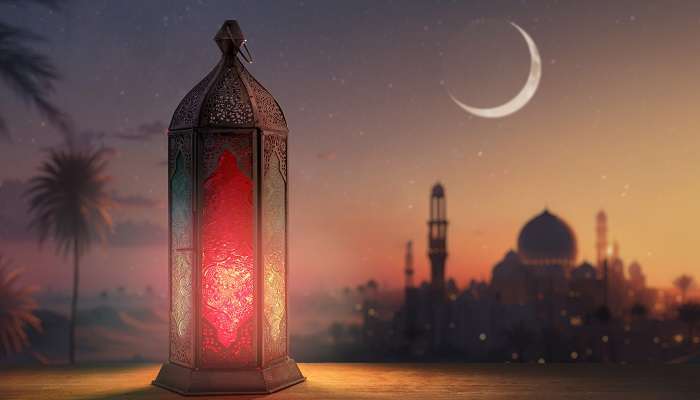 Lanterne arabe ornementale avec bougie allumée qui brille la nuit dans la mosquée