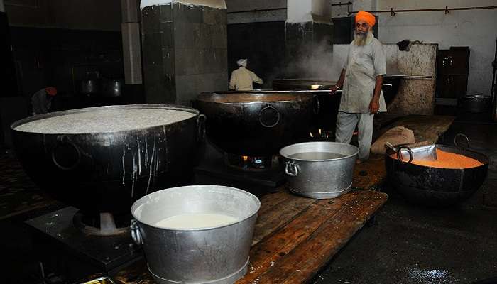 A picture showing a volunteer preparing the langar for the Golden Temple.