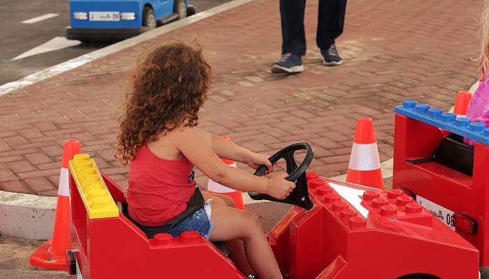A girl driving a Lego toy car at Legoland Dubai
