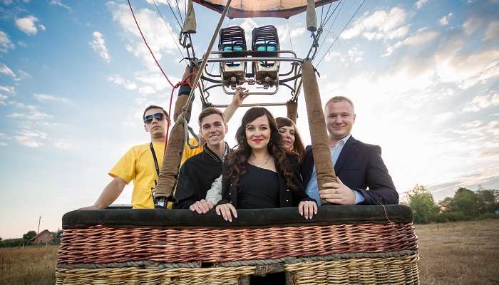 A happy group of people posing on a hot air balloon ride