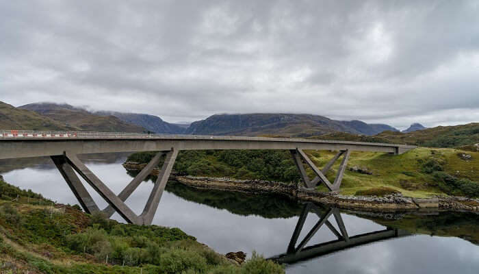 The breathtaking view of Kylesky Bridge in Assynt over the sea Loch Glencoul, among the hidden gems in Scotland