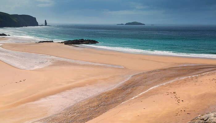 The scenic landscape of an isolated beach in Sutherland, Sandwood Bay; among the hidden gems in Scotland
