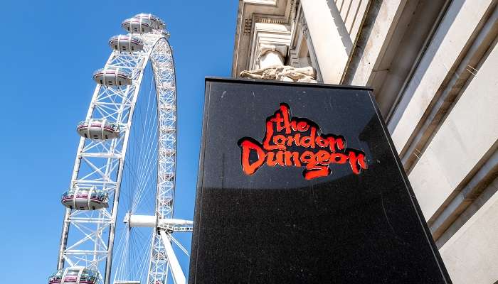 An entrance view of The London Dungeon, one of the top amusement parks in London, against the backdrop of blue sky