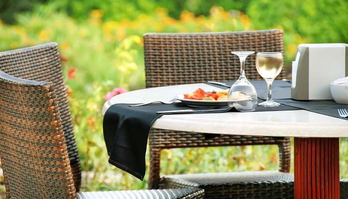Table extérieure avec assiette servie et verres à vin à The Garden Restaurant Lodhi Garden,