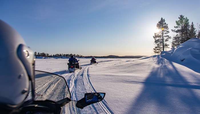 The breathtaking view of snowmobiling on the frozen lake of Inari.