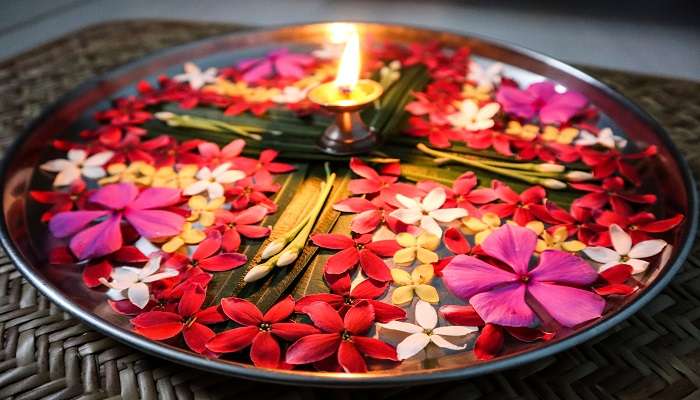 The plate for pooja, adorned with fresh flowers and diya.