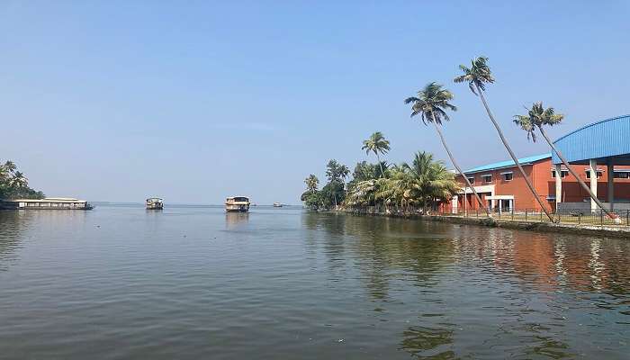 Crystal clear Alleppey Backwaters and boats resting on them near Alappuzha Temple