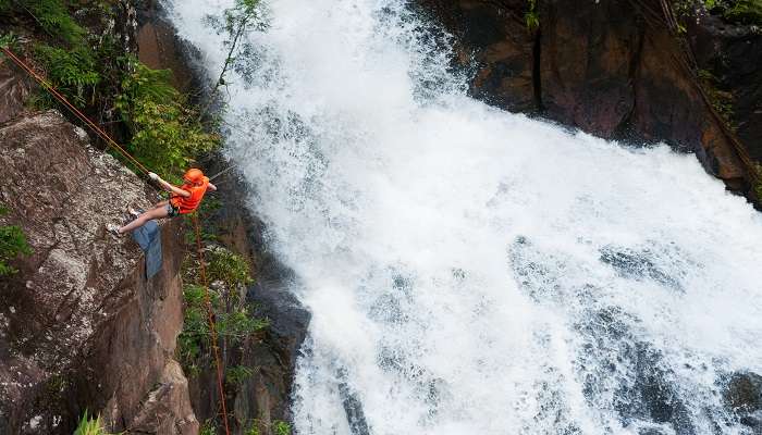 Adventure seeker rappels at Datanla waterfall.