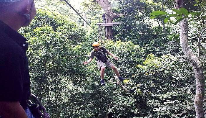 Joyful tourist zooms down Zipline in Bangkok