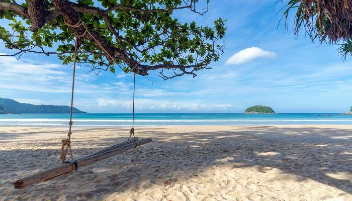 Tranquil wooden swing on Kata Beach in Phuket with serene ocean views.