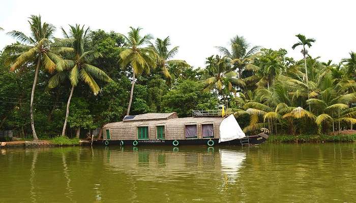 The serene view of a houseboat in Alleppey during the road trip from Kochi to Trivandrum