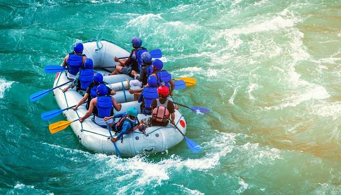 Group of rafters navigating through the rapids of the Ganges River