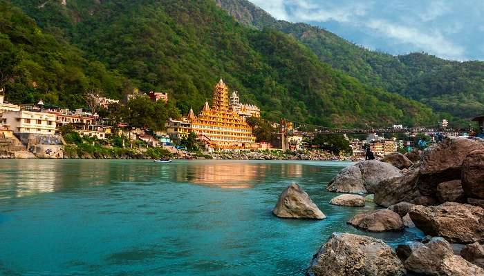 Hikers trekking through scenic trails surrounded by greenery and mountains in Rishikesh.