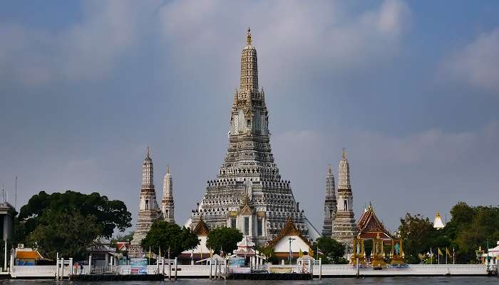 Silhouette of Wat Arun against a colorful sunset sky, an essential stop on Rattanakosin Island