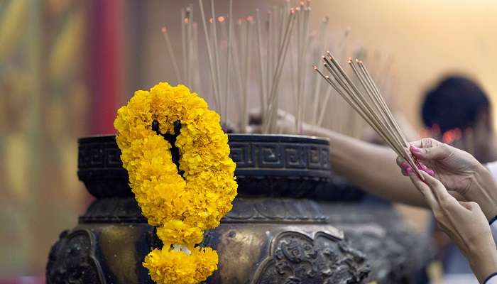 People burning incense sticks while praying 