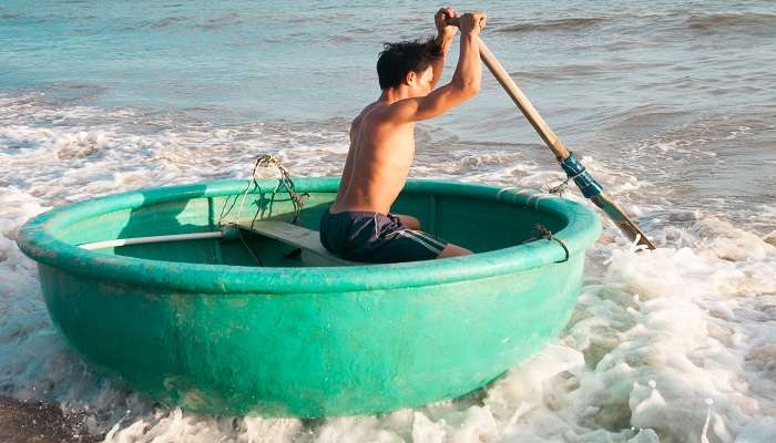 Travel Guide for Vietnam - Fisherman in traditional Vietnamese round boat, Phan Thiet, Bin Thuan