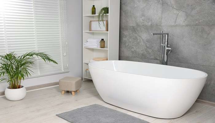 A white clean, and well-maintained modern bathtub in a hotel bathroom