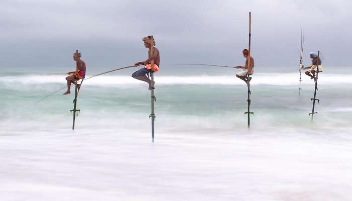 Man standing on bamboo for stilt fishermen Sri Lanka