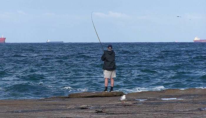 A tourist enjoying deep sea fishing at Pereybere Beach 