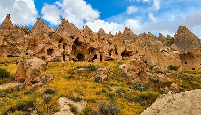 Tourists wandering at marvels of Goreme Open-Air Museum near Soganli Valley. 