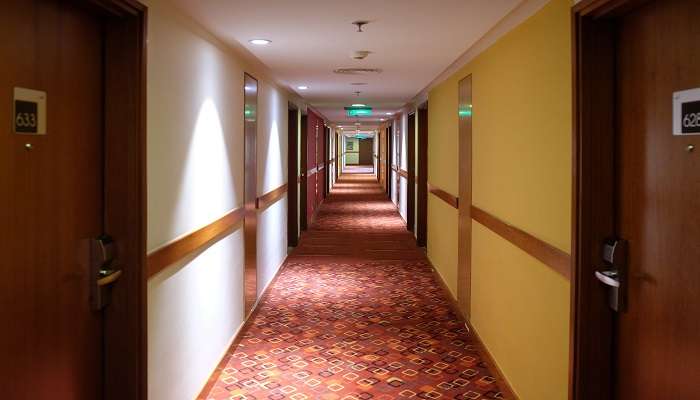 A long, calm hotel corridor with down-lighting