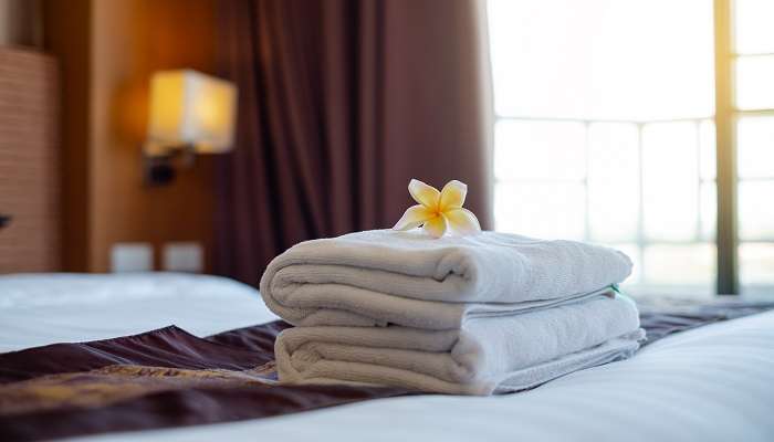 Folded towels stacked upon each other on the hotel bed