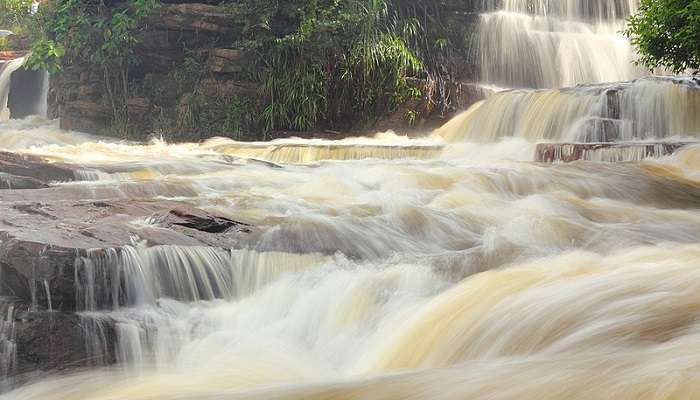 Visit the Kbal Chhay Waterfall, surrounded by lush greenery and flowing water.
