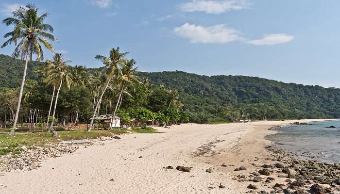 Khlong Chak Beach with blue waters and cloudy skies.