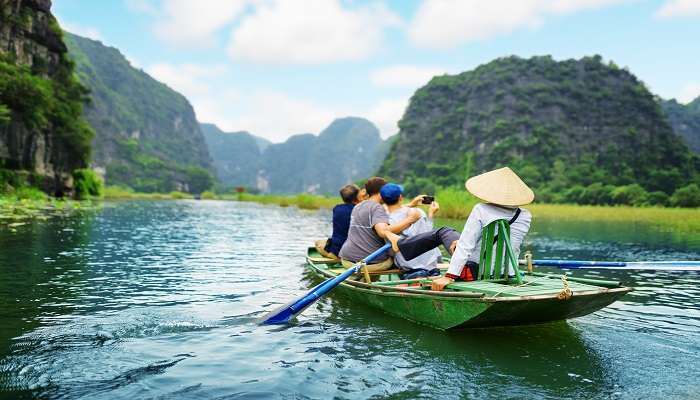 Vietnam Travel Guide - Tourists in a boat in the Ngo Dong River, Tam Coc, Ninh Binh