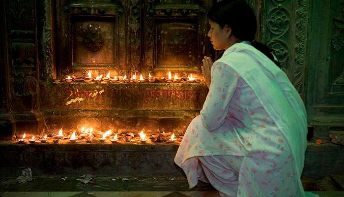 A devotee offering prayers inside a temple