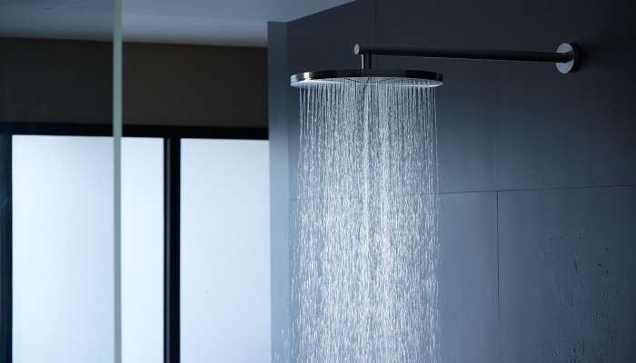 A Grey colour showerhead with water running on a dark background at one of the top resorts in Phan Thiet